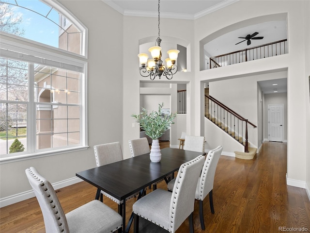 dining space featuring baseboards, ornamental molding, wood finished floors, and a wealth of natural light