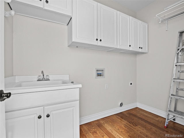 laundry area with cabinet space, washer hookup, a sink, baseboards, and wood finished floors