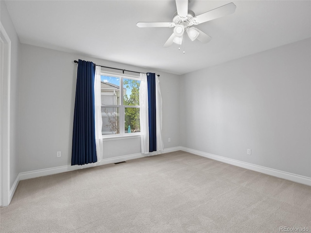 spare room featuring baseboards, light colored carpet, and visible vents