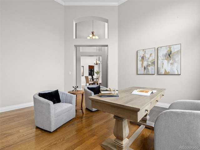 office featuring crown molding, baseboards, wood finished floors, and a chandelier