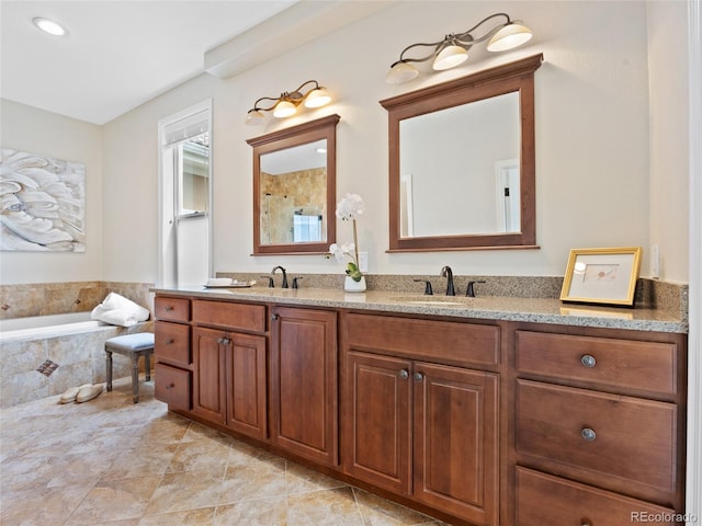 bathroom with double vanity, a sink, and a bath