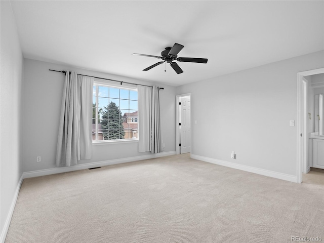 spare room with baseboards, visible vents, and light colored carpet