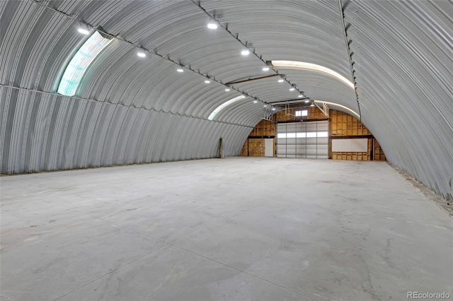 interior space featuring concrete flooring and vaulted ceiling