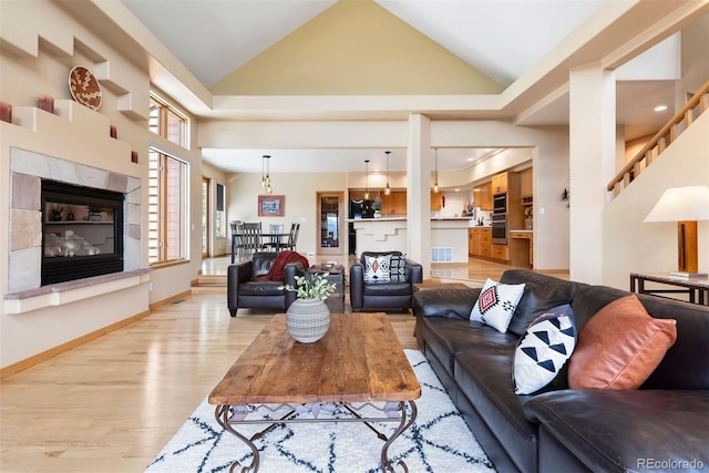 33095 Bergen Mountain Rd, Evergreen, CO 80439 - living room with vaulted ceiling, light wood-style floors, and a tiled fireplace