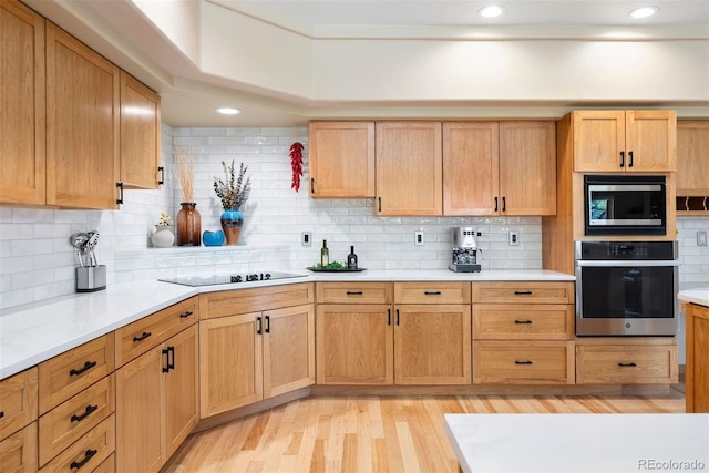 33095 Bergen Mountain Rd, Evergreen, CO 80439 - kitchen featuring appliances with stainless steel finishes, light wood finished floors, light countertops, decorative backsplash, and recessed lighting