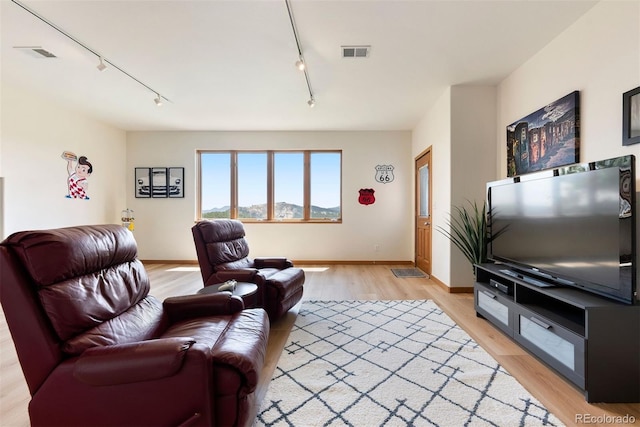 33095 Bergen Mountain Rd, Evergreen, CO 80439 - living room featuring track lighting, light wood-style flooring, and baseboards