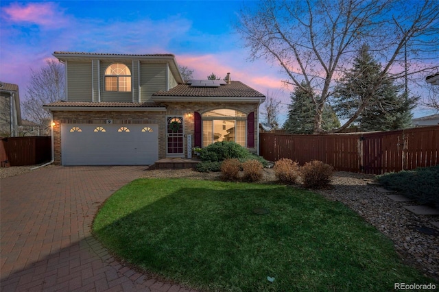 20000 Mitchell Pl Unit 9, Denver, CO 80249 - view of front facade featuring a tile roof, fence, roof mounted solar panels, and decorative driveway