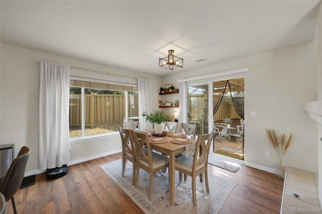 20000 Mitchell Pl Unit 9, Denver, CO 80249 - dining space featuring baseboards, visible vents, wood finished floors, and a chandelier