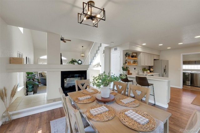 20000 Mitchell Pl Unit 9, Denver, CO 80249 - dining space with light wood-type flooring, washer / clothes dryer, a multi sided fireplace, and recessed lighting