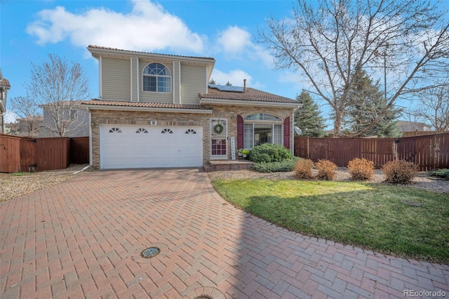 20000 Mitchell Pl Unit 9, Denver, CO 80249 - view of front of house featuring decorative driveway, solar panels, fence, and an attached garage