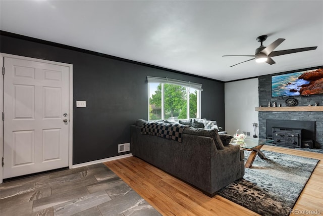 147 Wallace St, Northglenn, CO 80234 - living room featuring crown molding, a ceiling fan, and a wood stove
