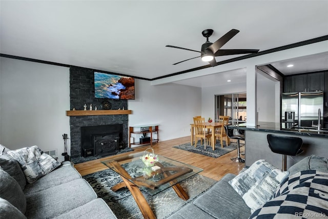 147 Wallace St, Northglenn, CO 80234 - living room with a ceiling fan, wood finished floors, ornamental molding, and a fireplace