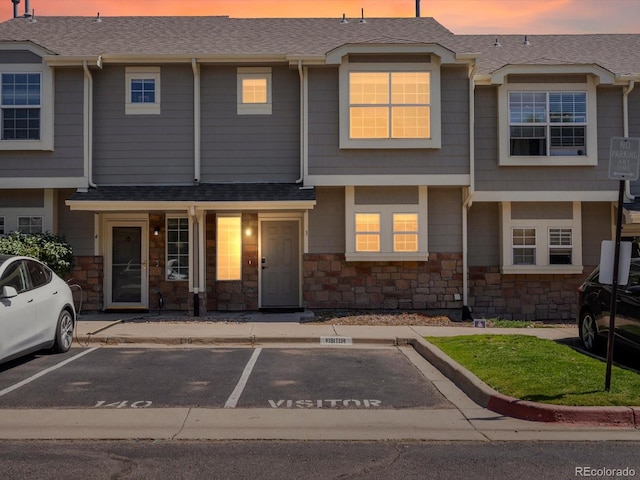9024 Gale Blvd Unit 3, Thornton, CO 80260 - view of property with uncovered parking, stone siding, and a shingled roof