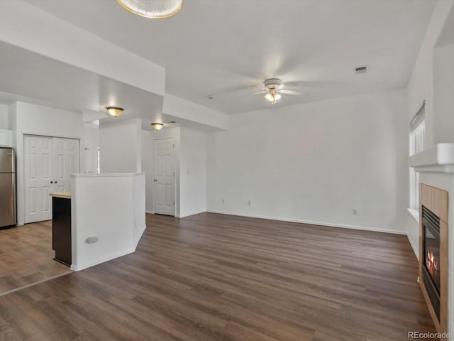 9024 Gale Blvd Unit 3, Thornton, CO 80260 - unfurnished living room featuring a ceiling fan, a tile fireplace, and dark wood finished floors