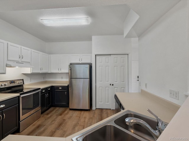 9024 Gale Blvd Unit 3, Thornton, CO 80260 - kitchen with appliances with stainless steel finishes, white cabinets, under cabinet range hood, light wood-style flooring, and light countertops