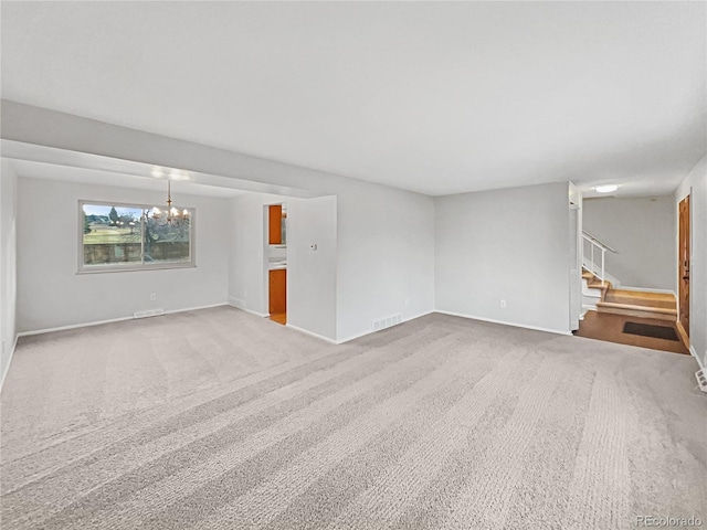 unfurnished living room featuring carpet flooring and a notable chandelier