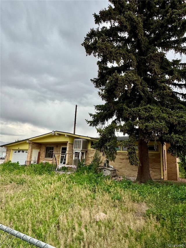 132 Amherst St, Colorado Springs, CO 80911 - view of front of home with a garage and brick siding