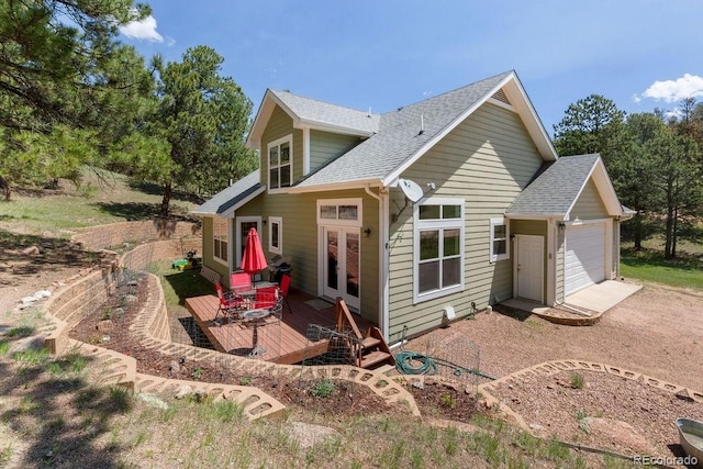 1563 Southpark Rd, Florissant, CO 80816 - back of property featuring roof with shingles, a deck, french doors, dirt driveway, and an attached garage