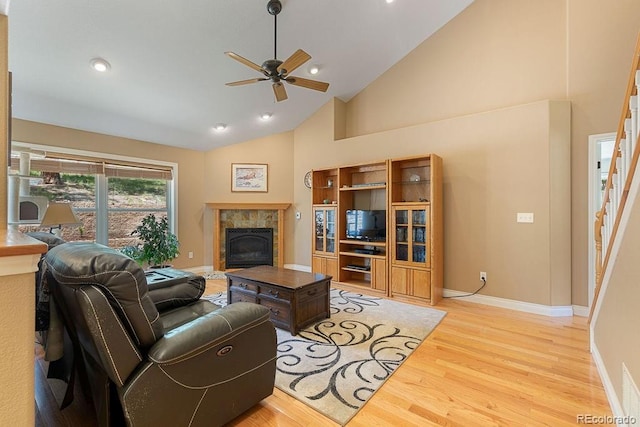1563 Southpark Rd, Florissant, CO 80816 - living area with a tile fireplace, light wood-type flooring, a ceiling fan, stairs, and high vaulted ceiling