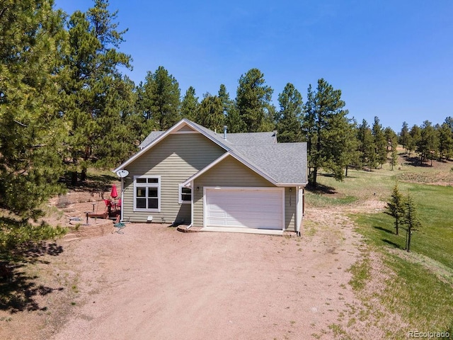 1563 Southpark Rd, Florissant, CO 80816 - view of front facade with dirt driveway, a garage, and roof with shingles