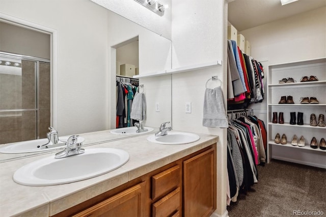 bathroom with a shower with shower door and vanity