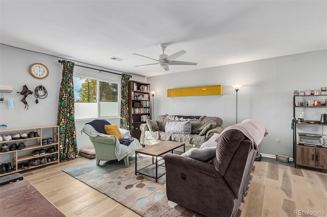 living room featuring light hardwood / wood-style flooring and ceiling fan