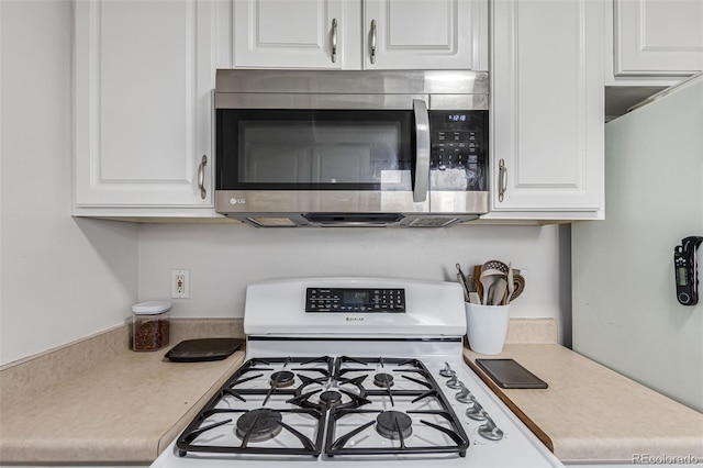 kitchen featuring white cabinets and white gas range oven