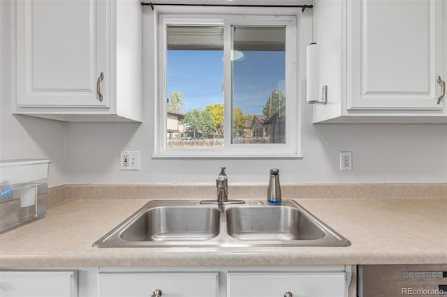 kitchen featuring sink, white cabinets, and dishwasher