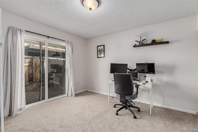 carpeted office space featuring a textured ceiling