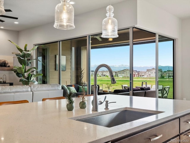 2113 Fountain Cir, Erie, CO 80516 - kitchen with a sink, plenty of natural light, hanging light fixtures, light stone counters, and recessed lighting