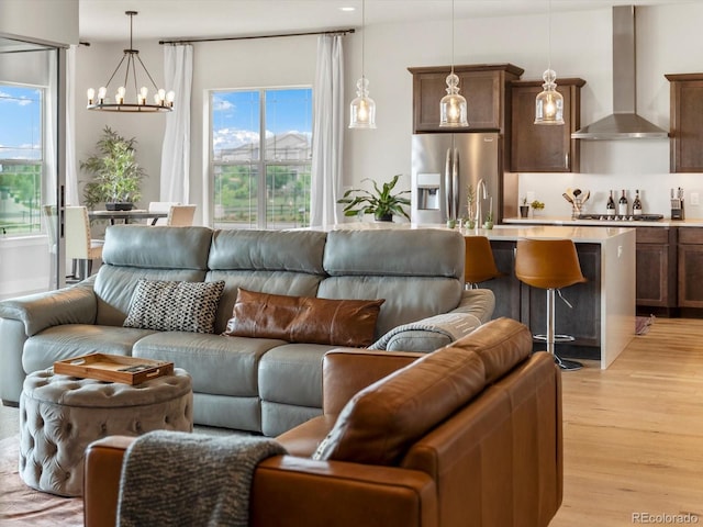 2113 Fountain Cir, Erie, CO 80516 - living area featuring a chandelier, light wood finished floors, and healthy amount of natural light