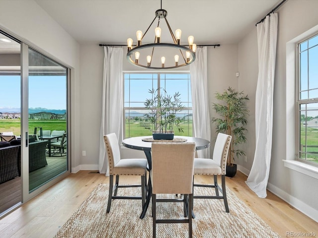 2113 Fountain Cir, Erie, CO 80516 - dining room with plenty of natural light, a chandelier, light wood finished floors, and baseboards