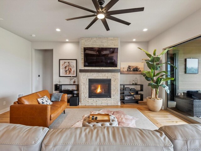 2113 Fountain Cir, Erie, CO 80516 - living area with a ceiling fan, wood finished floors, a stone fireplace, and recessed lighting