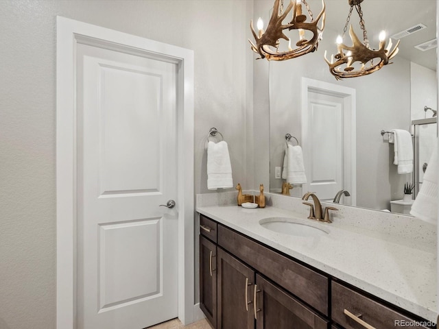 2113 Fountain Cir, Erie, CO 80516 - bathroom featuring a chandelier, vanity, and a shower