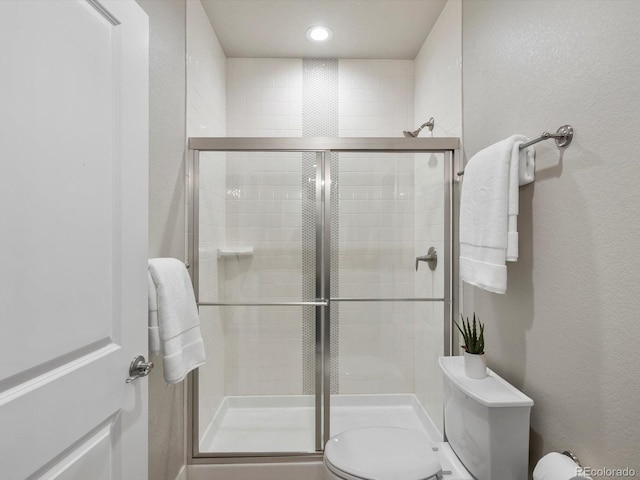 2113 Fountain Cir, Erie, CO 80516 - bathroom with toilet, a shower stall, a textured wall, and recessed lighting