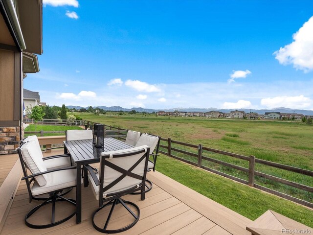 2113 Fountain Cir, Erie, CO 80516 - wooden terrace with outdoor dining area, a mountain view, and a view of countryside