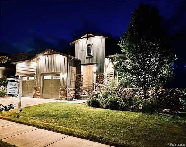 2113 Fountain Cir, Erie, CO 80516 - view of front of property with stone siding, board and batten siding, a yard, concrete driveway, and a garage