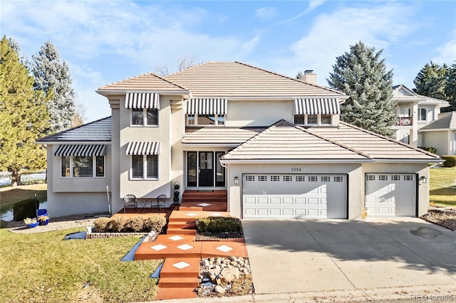 view of front of house featuring a garage and a front lawn