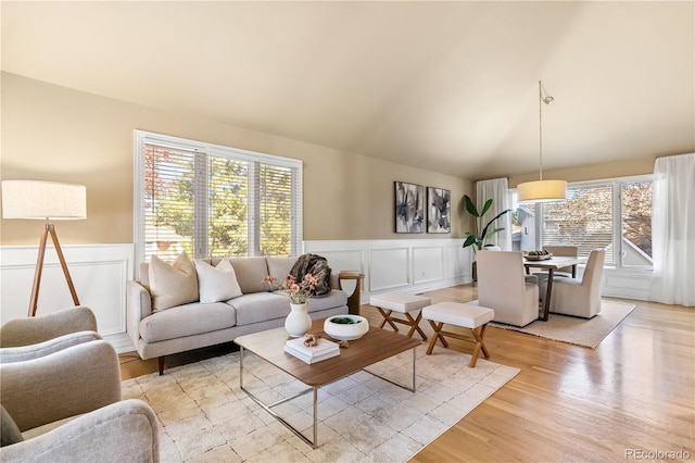 living room with light hardwood / wood-style flooring and vaulted ceiling