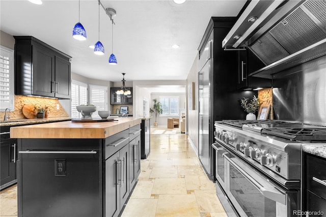 kitchen featuring exhaust hood, pendant lighting, stainless steel stove, a kitchen island, and butcher block counters