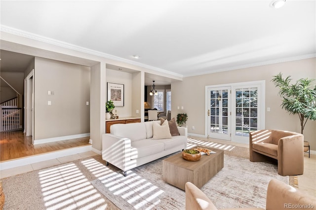 living room with hardwood / wood-style flooring, an inviting chandelier, and ornamental molding