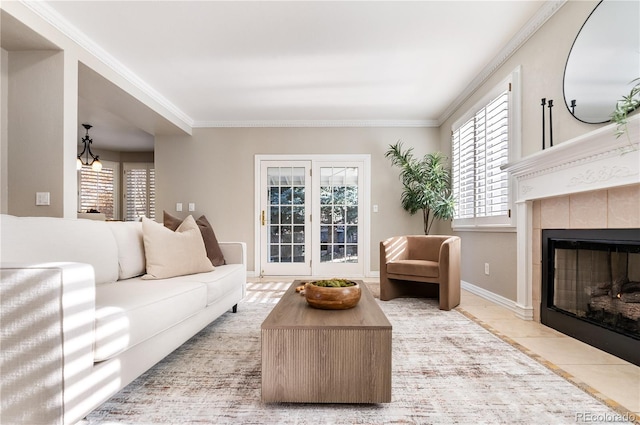 living room featuring an inviting chandelier, light tile patterned floors, ornamental molding, and a tiled fireplace