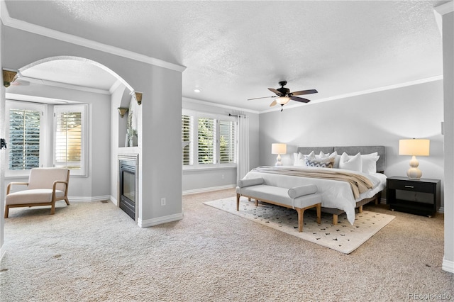 bedroom with ceiling fan, light carpet, a textured ceiling, and ornamental molding