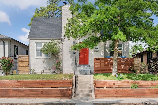3509 N Monroe St, Denver, CO 80205 - view of front of home with brick siding, a chimney, and a shingled roof