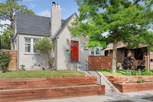 3509 N Monroe St, Denver, CO 80205 - view of front of home with brick siding, a chimney, and a shingled roof