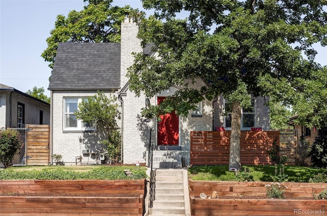 3509 N Monroe St, Denver, CO 80205 - view of front of home featuring a shingled roof, a chimney, and brick siding