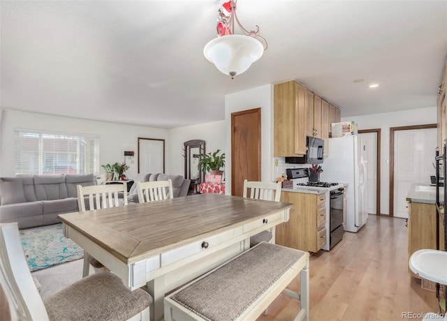 kitchen featuring hanging light fixtures, light wood-type flooring, and white range with gas cooktop