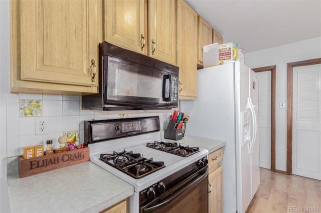 kitchen featuring black microwave, light countertops, decorative backsplash, and range with gas cooktop