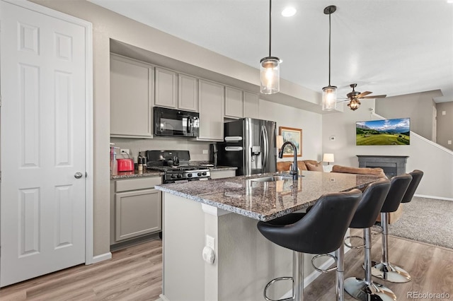23534 E 5th Pl, Aurora, CO 80018 - kitchen featuring black microwave, range with gas stovetop, stainless steel refrigerator with ice dispenser, gray cabinets, and a ceiling fan