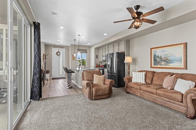 23534 E 5th Pl, Aurora, CO 80018 - living area featuring light colored carpet, ceiling fan, and recessed lighting